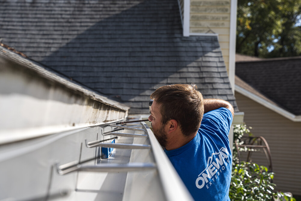 professional in blue shirt installing gutter guard