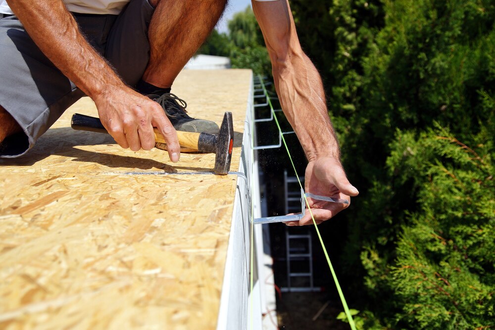 professional using hammer to install gutter